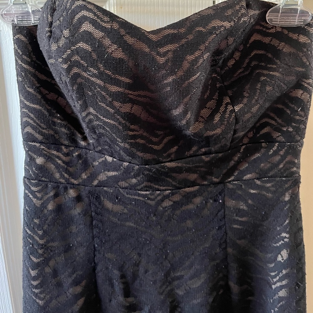 Black cocktail dress with tan under layer. Animal print design. Mid-thigh length